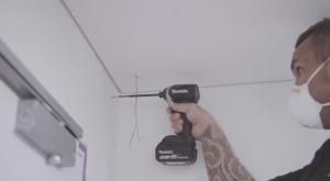 Handyman screwing a screw with a drill