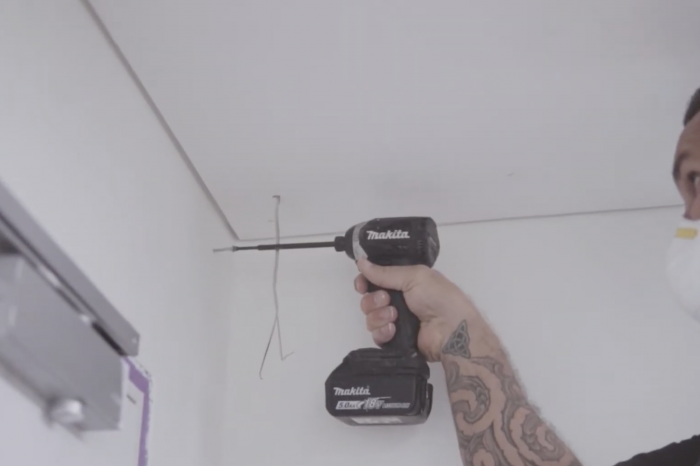 Handyman screwing a screw with a drill